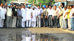 Residents of localities around the Gujja Peer road protest over its dilapidated condition in Jalandhar on Tuesday. Tribune Photo: Malkiat Singh