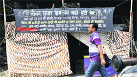 A man walks past a makeshift clinic of a quack in Jammu.