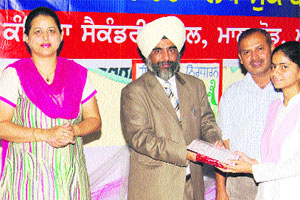 Chairman, District Legal Services Authority and District and Sessions Judge, HS Madan honours a student at Government Girls Senior Secondary School in Amritsar on Wednesday. 