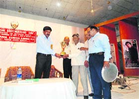 A freedom fighter honours Kangra Deputy Commissioner C Paulrasu at a function in Kangra on Wednesday