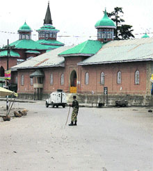 A CRPF jawan patrols a street in the curfew-bound Shopian on Wednesday. 