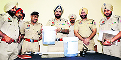Police Commissioner Paramjit Singh Gill shows the seized contraband in Ludhiana on Wednesday