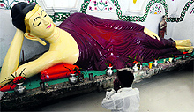 A Bangladeshi Buddhist prays in a temple which was vandalised during riots in 2012 at Ramu, 350 km southeast of Dhaka, on Wednesday. Nineteen monasteries and temples that were heavily damaged have been rebuilt