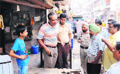 A shopkeeper argues with a Municipal Corporation team during the house tax recovery drive at Bhagtanwala in Amritsar on Thursday.