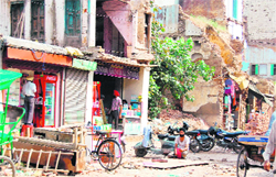 Shopkeepers continue their trades from tiny shops, while debris of demolished structures still lies in front of their shops near Jallianwala Bagh in Amritsar