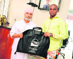 John Uche Jesus (right) hands over his collection of designer clothes to Dr Anil P. Joshi, founder of HESCO, in New Delhi on Thursday for the disaster-affected people of the state