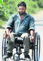 Pawan Kumar, a grocery shop owner, commutes on his Leveraged Freedom Chair in Sirsa. A Tribune photograph