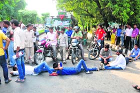 Students block the road outside Jammu University campus on Thursday