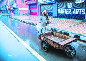 A man pushes a hand-cart in Srinagar on Thursday