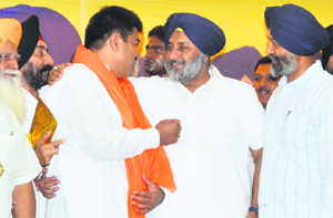 Punjab Deputy Chief Minister Sukhbir Singh Badal presents a siropa (robe of honour) to former president of the District Youth Congress (Ludhiana-Urban) Dimple Rana, who joined the SAD in Ludhiana on Thursday. 