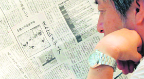 A man reads a Japanese newspaper reporting on cartoons published in a French newspaper, in Tokyo on Thursday.