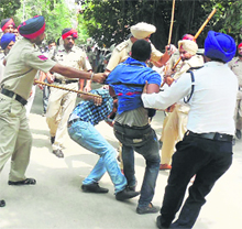 Policemen cane-charge students in Barnala on Friday.