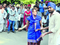 Artistes perform a street play on the campus.