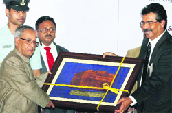 President Pranab Mukherjee receives a memento from Bengal CCI president Kallol Datta in Kolkata on Saturday.  PTI