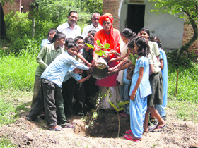 Triveni Baba plants a sapling at Government Girls High School on HAU campus, Hisar. 