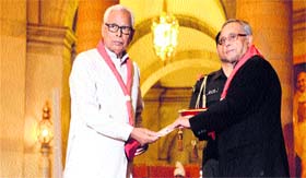 President Pranab Mukherjee gives an award to Governor NN Vohra in New Delhi.