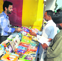 Farmers buy books at a stall during Kisan Mela on Saturday. Tribune photo: himanshu Mahajan 