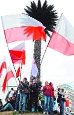 Trade union members wave Polish flags as they demonstrate against the policies of an unpopular and increasingly fragile centre-right government in Warsaw on Saturday. AFP