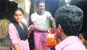 Volunteers of Making a Difference, an NGO, distribute food packets at Bihari Basti in Dehradun on Sunday.