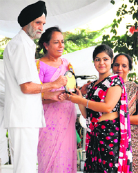 Amarjeet Singh, Director-General, Education, honours a student during a felicitation ceremony at SD College in Jalandhar. 