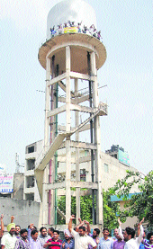 Teachers protest at the water tank of the bus stand in Jalandhar on Sunday. 