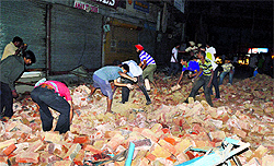 People clear the debris of a building that collapsed near Rekhi Cinema