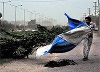 A man braves the storm in Ludhiana on Sunday