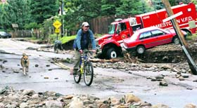 A man rides down a damaged road in flood-ravaged Colorado.