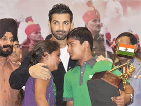 M.S. Bitta, chairman of the All India Anti-Terrorist Front and actorJohn Abraham console the children of a martyr while honouring him with Veer Bravery Award during the commemorative programme Zara Yaad Karo Qurbani in New Delhi on Monday. 