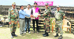 Army officers distribute furniture and sports items at the Government Middle School, Budhan, on Monday. 
