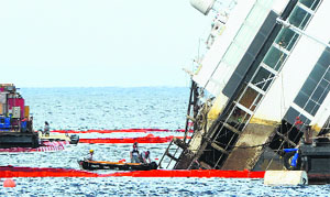 Salvage crew workers work on a side of the Costa Concordia in Italy on Monday.