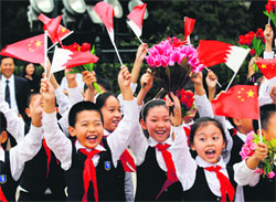 Children wave national flags of Bahrain and China as they prepare for the welcoming ceremony for the Bahrain King hosted by the Chinese President in Beijing on Monday.