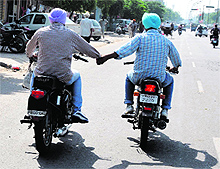 Two youths ride their motorbikes holding each others hands in a sign of great bonding on a road in Bathinda. However, the ride can invite danger in view of the grim traffic scenario in the city