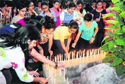 Remembering college mate: Students light candles in memory of Himanshu, who died when a squall hit the city, at GGDSD College, Sector 32, in Chandigarh on Tuesday. Tribune photo: Parvesh Chauhan
