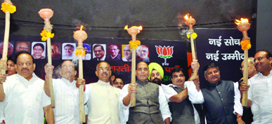 BJP president Rajnath Singh and other senior party leaders raise torches during the launch of Delhi election campaign at Talkatora Stadium