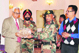 Governor N N Vohra presents a memento to an Army officer at Raj Bhawan in Srinagar on Monday