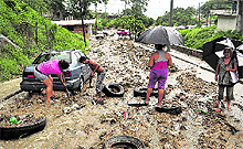 A couple tries to remove their car from a swampy street in Acapulco, Mexico, after heavy rains hit the area