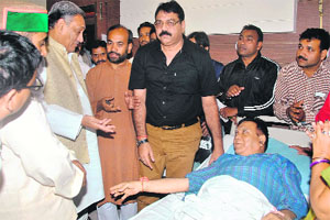 Chief Minister Vijay Bahuguna enquires after the health of Congress worker Vivekanand Khundari at a local hospital in Dehradun on Wednesday. 