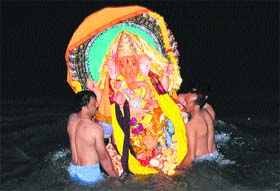 Devotees immerse the idol of Lord Ganesha in the Beas in Mandi on Wednesday