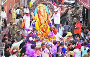 Devotees take part in a procession to take Lord Ganeshas idol for immersion in the Tawi and (below) devotees immerse the Lord idols in water marking the end of the Ganesh Mahotsav in Jammu on Wednesday.
