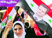 A supporter of President Basher al-Assad waves a flag during a rally in Damascus