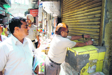 A house tax team of the MC seals a shop near Durgiana Temple in Amritsar after its proprietor failed to clear dues.
