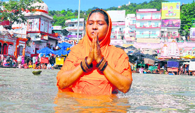 On the first day of Shradh, a woman takes a holy dip in the Ganga and prays at Brahmkund, Har-ki-Pauri, in Haridwar on Friday.