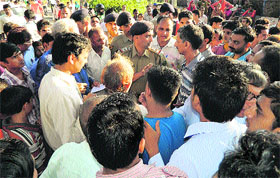 SHO MS Manhas presuades protesters to lift the blockade at Ansoli in Kangra on Thursday. 