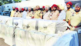 Police officials stand with the seized drugs in Ludhiana on Thursday