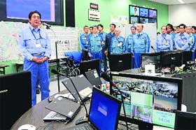 Japanese PM Shinzo Abe speaks to workers at the Tepco Centre in Okuma, Japan, on Thursday