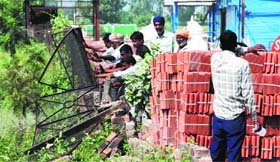 MC staff remove encroachments along the Chandigarh-Ambala highway at Zirakpur on Friday.