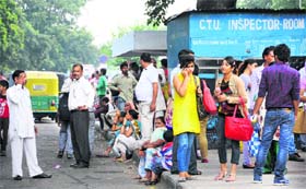 Passengers wait for a bus at the PGI bus stop.