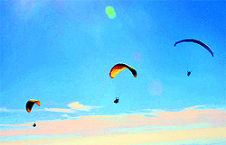 Tourists enjoy paragliding on sunny day in Billing on Friday