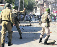 Police personnel fire teargas shells to disperse protesters in Srinagar on Friday.